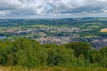 The View overlooking Otley Town in West Yorkshire seen from the wooded Chevin ridge to the south of the Town, with green fields in the background.