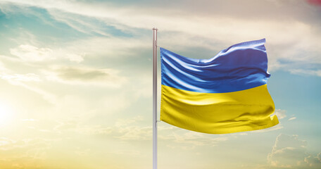 Ukraine national flag waving in beautiful sky. The symbol of the state on wavy silk fabric.