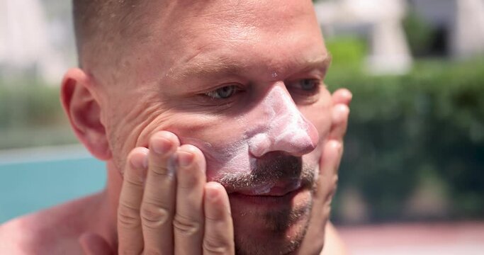 Man applying spf sunblock to body and face 4k movie slow motion. Skin care protection from ultraviolet radiation concept