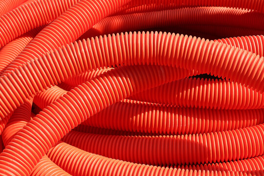 Abstract Red Industrial Background. Plastic Corrugated Pipes For Cable Laying.