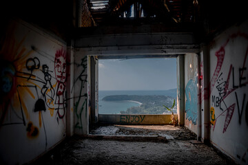 Gloomy interiors of an abandoned building. Empty room. Graffiti on the walls. Concrete room. Terrible abandoned hotel.