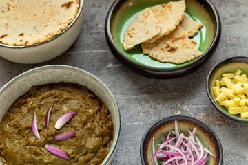 Sarson ka saag traditional Indian dish with corn bread (Makki di roti) with shallots and ginger. Homemade food meal.