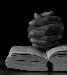 man praying to god with hands together Caribbean man praying with black background with people stock photos stock photo