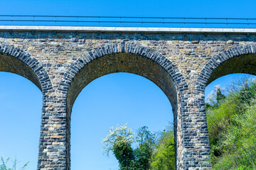 Historic stone railway viaduct on a sunny day against a blue sky