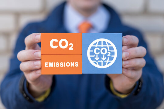 Man holding colorful blocks with icon of globe with CO2 and inscription: REDUCE CO2 EMISSION. Concept depicting the issue of carbon dioxide emissions and its impact on nature. CO2 pollution reduce.