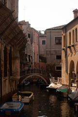 Fototapeta premium Boats on channel under buildings in old town in sunlight