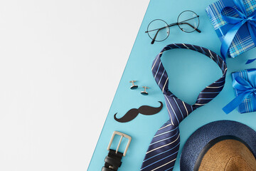 Father's Day celebration concept. Top view flat lay of gift boxes trendy necktie hat glasses cufflinks belt and paper mustache on light blue and white background with empty space for text or advert