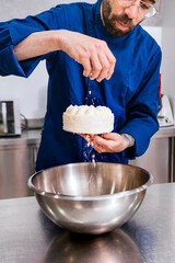 Coco Sprinkles: Close-Up of Pastry Chef's Hands Topping a Coconut Cake with Shredded Coconut