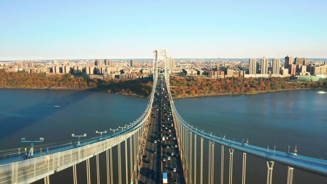 Aerial footage above George Washington Bridge with pull-back camera motion. The GWB is a double-decked suspension bridge spanning the Hudson River, connecting Fort Lee, NJ with New York City