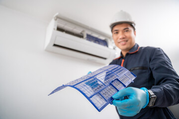 Air conditioner technician removes the air conditioner filter and shows the dusty air conditioner...