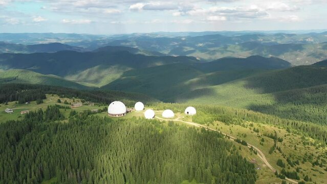 Abandoned radar station Pamir in Carpathian mountains, research station on top of the Pamir mountain in the Carpathians in Ukraine. large white balloons designs in the mountains among the fir trees. 
