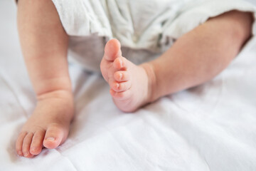 Small feet of a newborn baby. The concept of motherhood, breastfeeding.