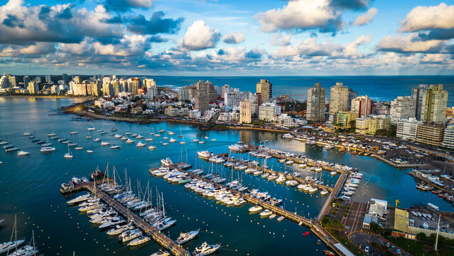 Drone shot revealing the picturesque coastal seaside city of Punta del Este called Miami beach of South America with waterside iconic urban skyline buildings at sunset, Uruguay
