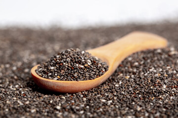 Chia seeds close-up with a wooden spoon. Chia seeds macro. Dry healthy supplement for proper nutrition.