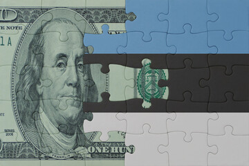 puzzle with the national flag of estonia and dollar money banknote. macro.concept.