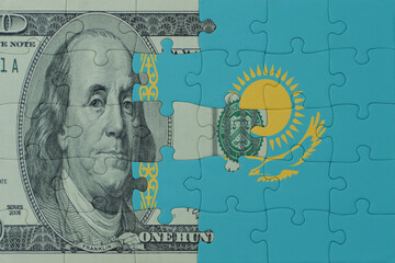 puzzle with the national flag of kazakhstan and dollar money banknote. macro.concept.