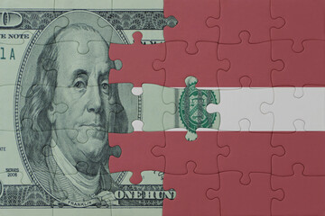 puzzle with the national flag of latvia and dollar money banknote. macro.concept.
