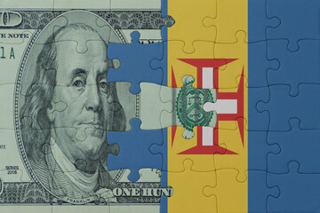 puzzle with the national flag of madeira and dollar money banknote. macro.concept.