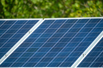 Obraz premium Solar photovoltaic panels mounted on stand-alone frame on backyard ground for generating of clean ecological electric energy. Concept of autonomous house