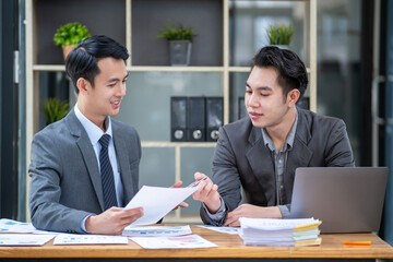 Young businessmen discussing project share idea talking in office, smiling happy business show document figure data information to discussing 