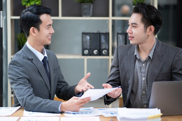 Young businessmen discussing project share idea talking in office, smiling happy business show document figure data information to discussing 