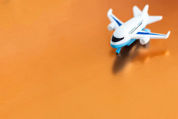 Small white airplane on orange background.