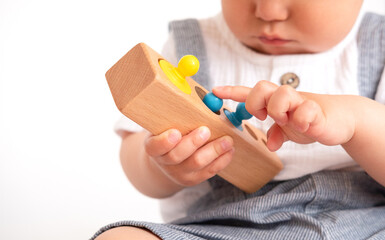 The child plays with colorful toy blocks. eco wooden toys. Little smart child playing natural toys. games for early development. Toy in children's hands close-up