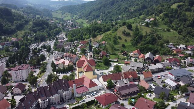 Drone footage of a European village with a church in the center.