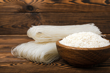Noodles with rice flour on a dark brown wood. Funchoza. Dry rice noodles.Close-up.Copy space. Place for text.
