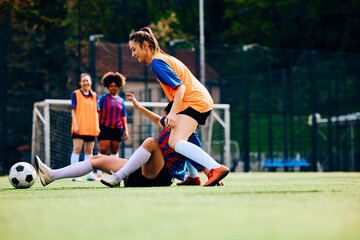 Fototapeta premium Soccer player fouls her opponent during practice on playing field.