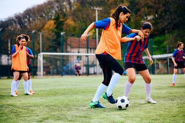 Obraz premium Female soccer players having sports training on playing field.