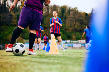 Naklejka premium Female goalkeeper practicing with ball during soccer training.