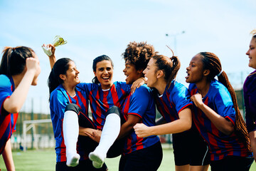 Obraz premium Cheerful women's soccer team celebrating winning first place on championship.