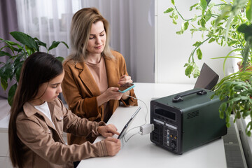 mother and daughter use a portable charging station