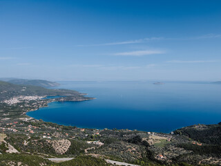 Fototapeta na wymiar Blue sea at the foot of the mountain range merges with the horizon