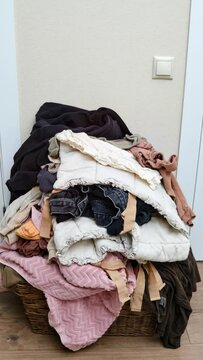 Pulling clothes out of the basket, stop motion vertical video. Sorting men s and women s clothing after washing, timelapse
