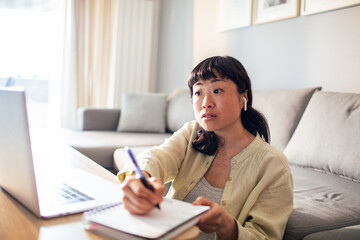 Young Japanese Woman using a laptop on a couch