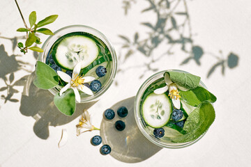Refreshing summer drink - cucumber infused water with ice, sage, cucumber and lemon blossom on the...