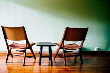 Comforting Openness - Capture a warm atmosphere with two empty chairs facing each other, symbolizing authentic conversations in a psychologically safe environment.