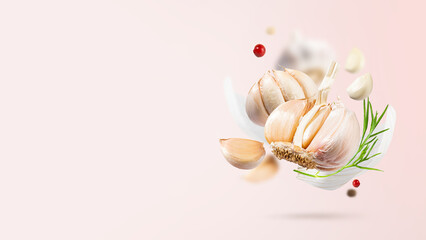 Flying Garlic with red and black pepper and herbs on light pink background. Spicy and fragrant...