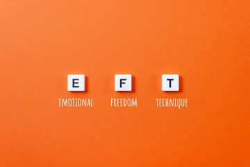 Letters EFT from plastic blocks and inscriptions Emotional Freedom Technique on orange background....