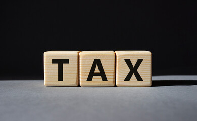 Tax symbol. Wooden cubes with word Tax. Beautiful grey background. Business and Finace and Tax concept. Copy space.