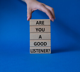 Listening skills symbol. Wooden blocks with words Are you a good Listener. Beautiful blue background. Businessman hand. Business and Are you a good Listener concept. Copy space.