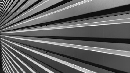 Natural abstract background of grey metallic fence. Black and white footage. Perspective concept.