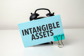 intangible assets is written in a blue sticker near a black alarm clock