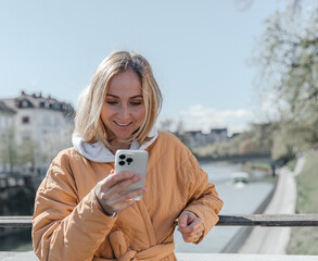 A beautiful young stylish woman walking in the city. Spring mood, dreaming and waiting, a lifestyle concept