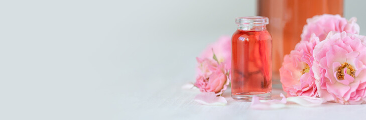 Premium skin care beauty treatment with pink rose petals. Plant-based pure organic ingredients in cosmetics. Jar of body or face moisturiser, lotion. Flower extract, natural youth anti-age elixir