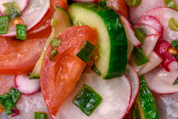 Delicious vegan salad of fresh vegetables of tomatoes, cucumbers and radishes