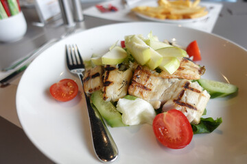 Grilled Fish Fillet with salad on a plate ,