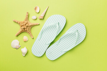 Striped flip flops on color background, top view